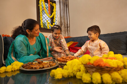 Family celebrating Diwali with traditional decorations and sweets