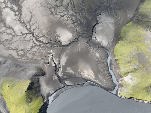 Aerial view of the glacial river delta and volcanic landscape near Langisjor, featuring dark sand patterns and vibrant green mossy terrain, Kirkjubaejaklaustur, Skaftarhreppur, Iceland.
