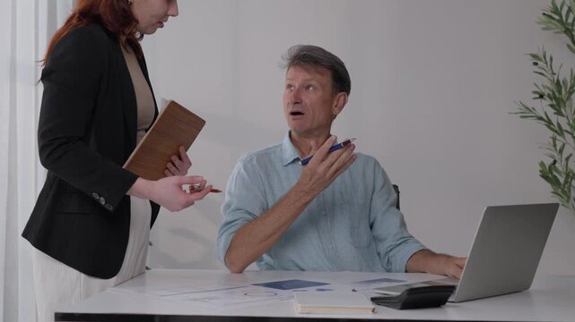 Stressed businessman reacting to bad news from colleague