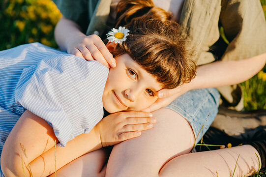 Young girl resting beside family member outdoors