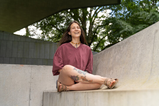 Woman with tattoos laughing expressing happiness outdoors