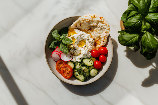 Sabzi khordan platter with a minimalist presentation of creamy cheese, rustic flatbread, and crisp raw vegetables