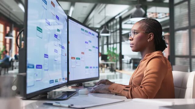 Business Analyst Reviews Automated Workflow System On Computer