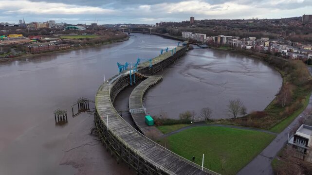Wide angle landscape perspective of entire Dunston Staiths structure, protruding out from Gateshead towards The Quayside - Gateshead, England