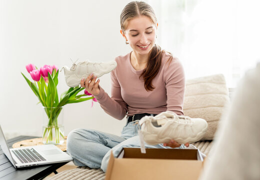 Girl Looking At Sneakers Bought Online And Shopping Online