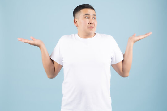 Young man showing a neutral indifferent expression with open palms and relaxed arms