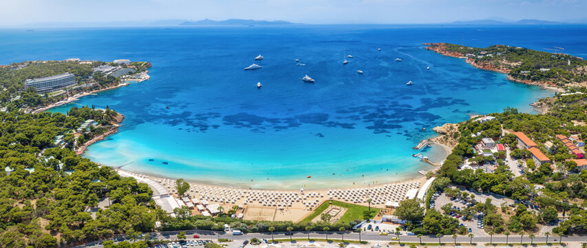 Panoramic aerial summer view of the famous luxury beach Astir in south Athens, bay of Vouliagmeni, Greece, with water sports over turquoise sea