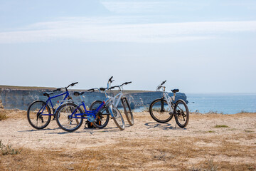 Fototapeta premium Three Bicycles Parked on Sea Cliff under Blue Sky in Summer