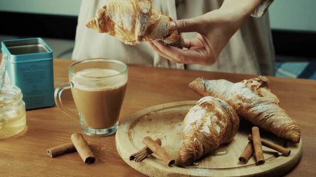 Dipping Fresh Sweet Croissant Into Glass Mug With Hot Coffee Milk. Bakery Dessert Preparation