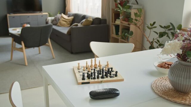 Chessboard resting on table in empty common room of retirement home, representing leisure activities for seniors. Clip for senior care marketing and retirement community promotions