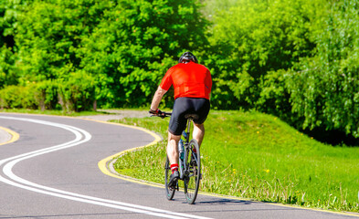Naklejka premium Cyclist ride on the bike path in the city Park 