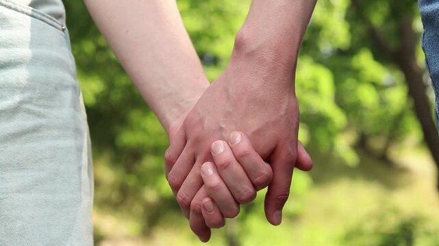Two women holding hands. Close-up of two women's hands holding each other. A symbol of trust, tenderness and LGBT relationships. Concept of love, friendship and equality