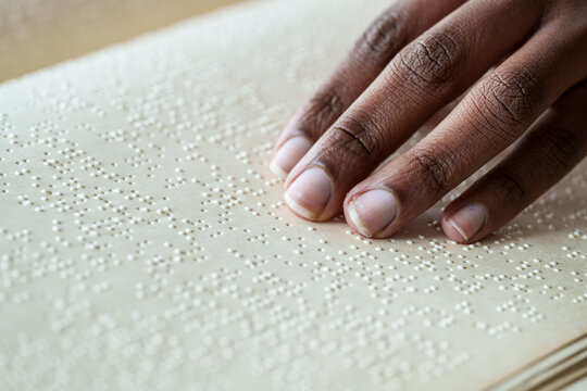 Woman reading braille text on page from book