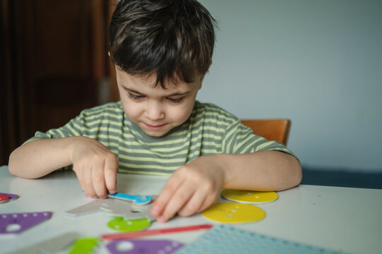 Boy designer assembling educational mechanics toy indoors