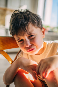 Sad child crying and looking at camera indoors at home