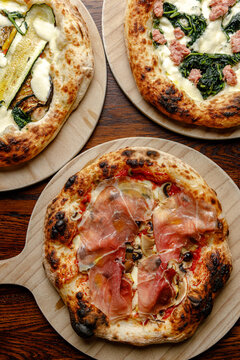 Prepared craft pizzas with various toppings in an authentic pizzeria