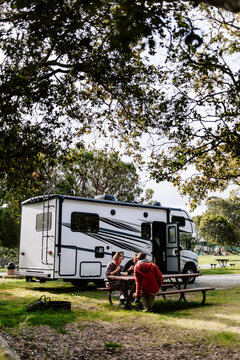Family enjoying meal at RV campsite in nature