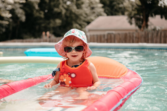 Toddler in pink pool float