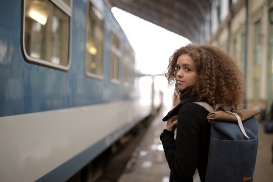 Woman with backpack looks back on platform
