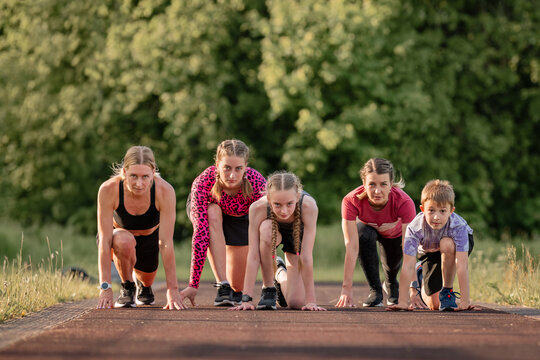 mixed-age group gets ready to start a race on the treadmill.