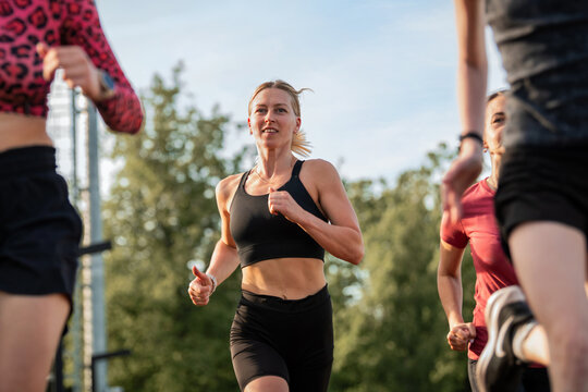 Athletic woman running with a group outdoors