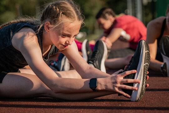 Teen girl stretching her hamstrings before a run