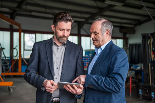 Engineers with digital tablet in workshop