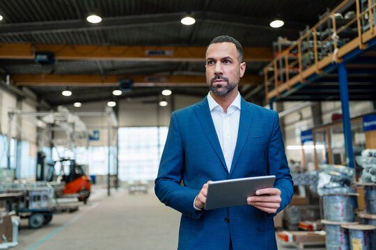 Businessman using tablet in a factory