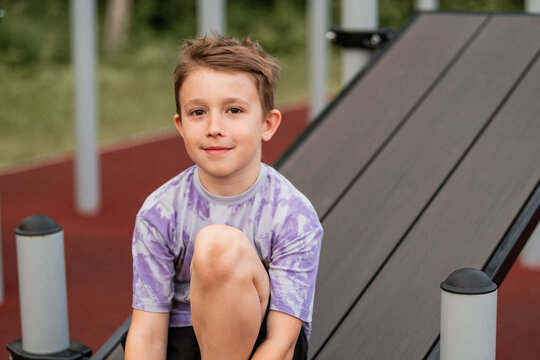Young boy smiling while sitting at outdoor gym