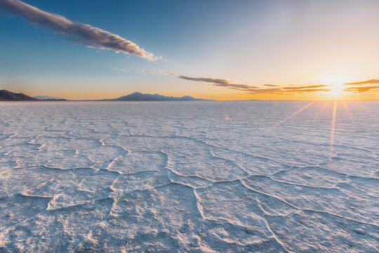 Golden sunrise over vast Bolivian salt flats
