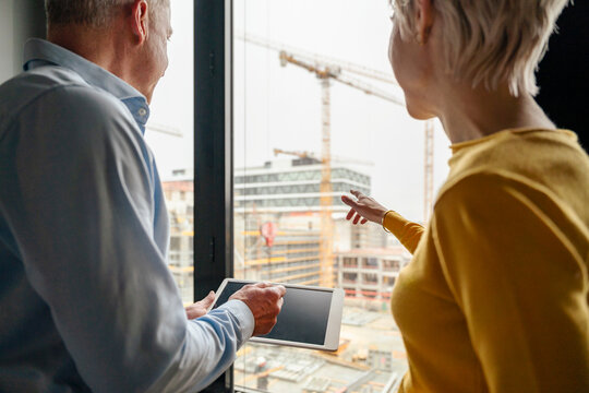 Architect and engineer view construction site holding tablet