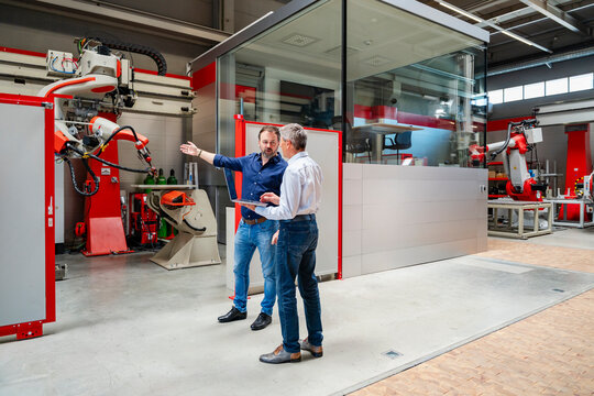 Manager and engineer discussing robot automation in factory