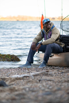 Smiling kayaker takes a break on the shoreline