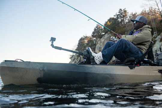 African American man fishing from a kayak on a lake