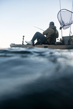 Water level view of a man fishing in a kayak