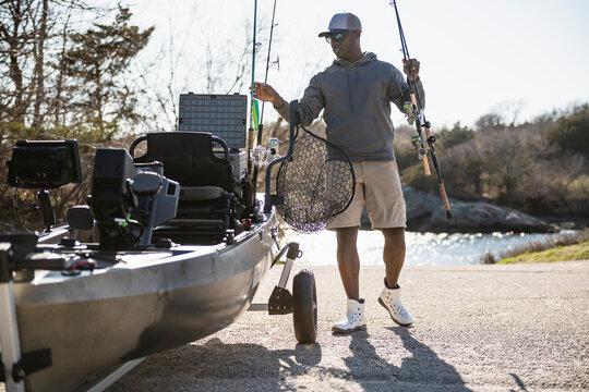 Fisherman preparing his kayak and gear for a fishing trip