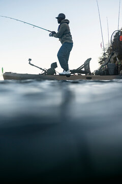 Split view of man standing and fishing from a kayak