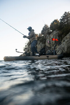 Black man standing and fishing from his kayak