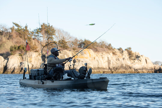 Man casting a lure from a fishing kayak