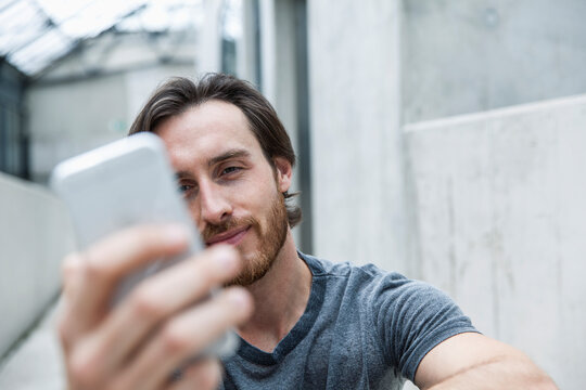 Portrait of young man looking at his smartphone