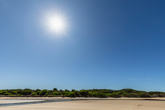 Sun shining against clear blue sky over Thompson Creek and Point Impossible Beach