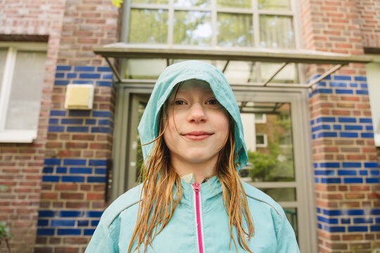 Portrait in a blue raincoat outdoors showing quiet confidence