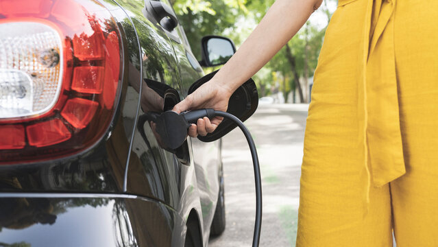 Mature woman charging electric car