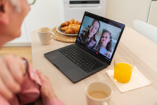 Family having a remote video call during breakfast at home
