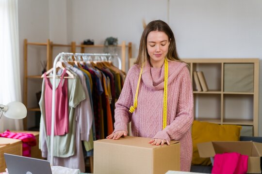 Entrepreneur packing cardboard box in home office