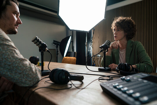 Presenter talking with guest in radio station