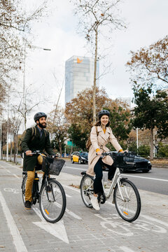 Couple riding e-bikes in the city on bicycle lane