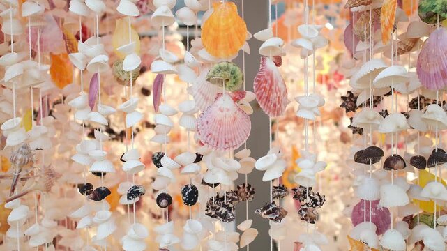 Colorful Seashell Curtain Background for Travel and Tourism. Close-up footage of decorative hanging seashell strands made from shells of various colors, shapes and sizes. Gentle movement creates a tro