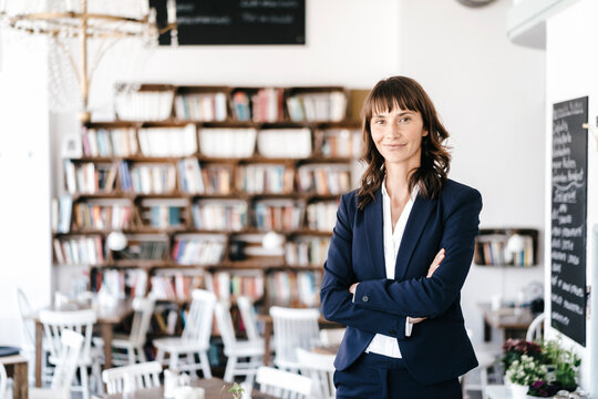 Businesswoman in cafe with arms crossed. looking at camera