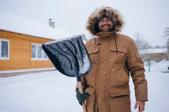Portrait of smiling man with snow shovel